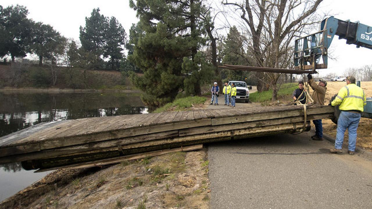 Staff from UC Davis Civil and Industrial Services remove the dilapidated boat dock from the Arboretum waterway. Arboretum waterway boat dock