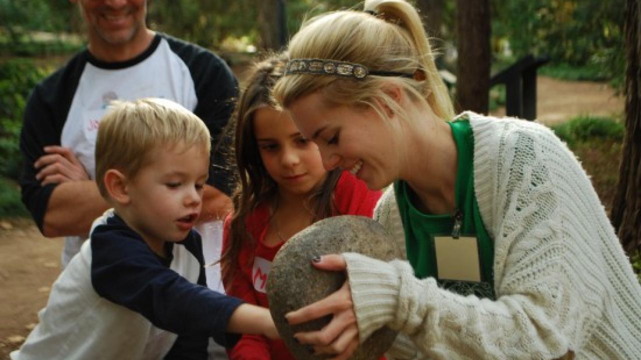 Students in the environmental education strand of the Arboretum and Public Garden’s Learning by Leading Program create events designed to engage all ages. Here adults and children learn about acorns and other Native American uses of California plants. Learning by Leading event