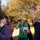 A group of UC Davis students birdwatching with binoculars 